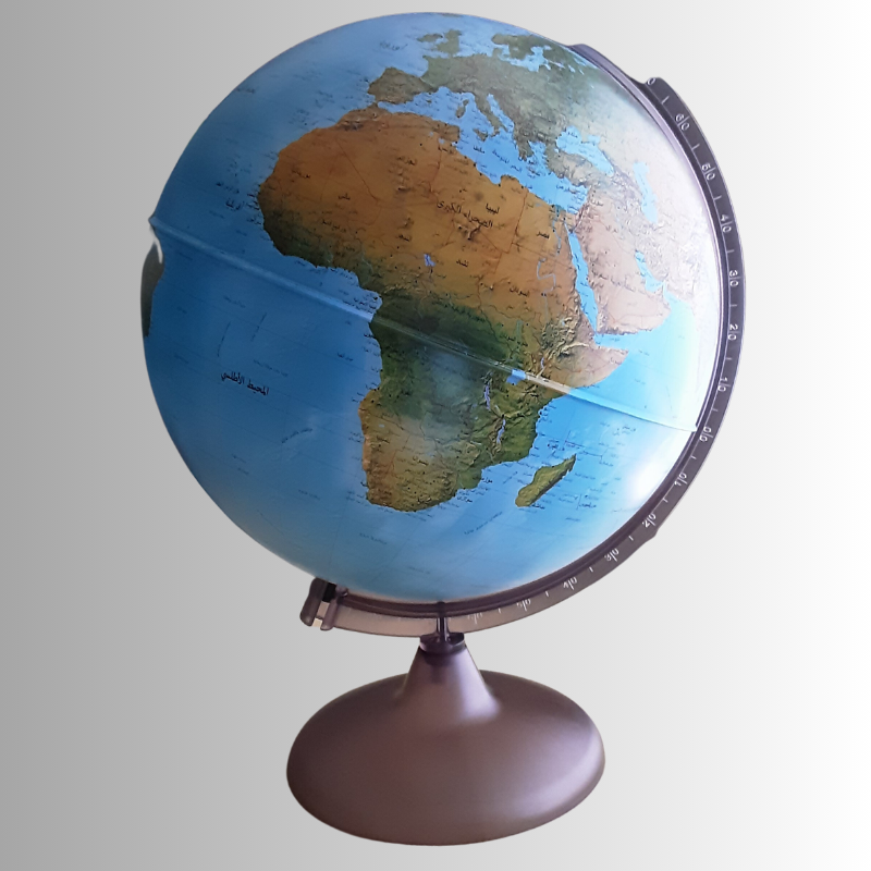 A 25 cm Arabic globe displayed on a wooden desk beside a laptop, with a focus on the African and European continents. The globe sits on a metallic base and features Arabic script for the country names